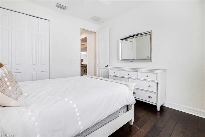 Bedroom with a closet, dark hardwood / wood-style floors, and ceiling fan