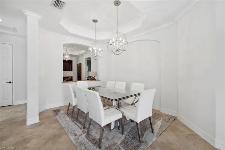 Dining area featuring crown molding, a chandelier, and a tray ceiling