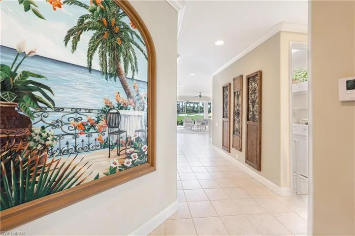 Hall with crown molding and light tile patterned flooring