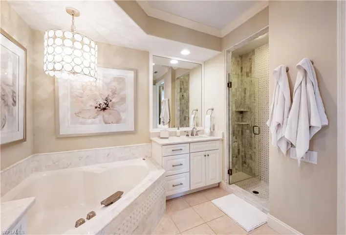 Bathroom with vanity, crown molding, shower with separate bathtub, and tile patterned flooring
