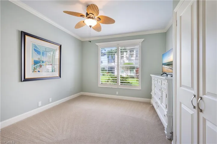 Unfurnished bedroom featuring crown molding, light colored carpet, and ceiling fan