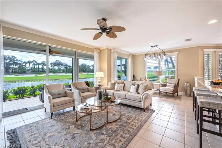 Sunroom featuring ceiling fan with notable chandelier