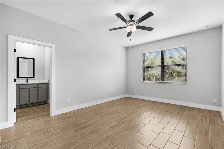 Full bath featuring vanity, a stall shower, a walk in closet, wood finish floors, and recessed lighting