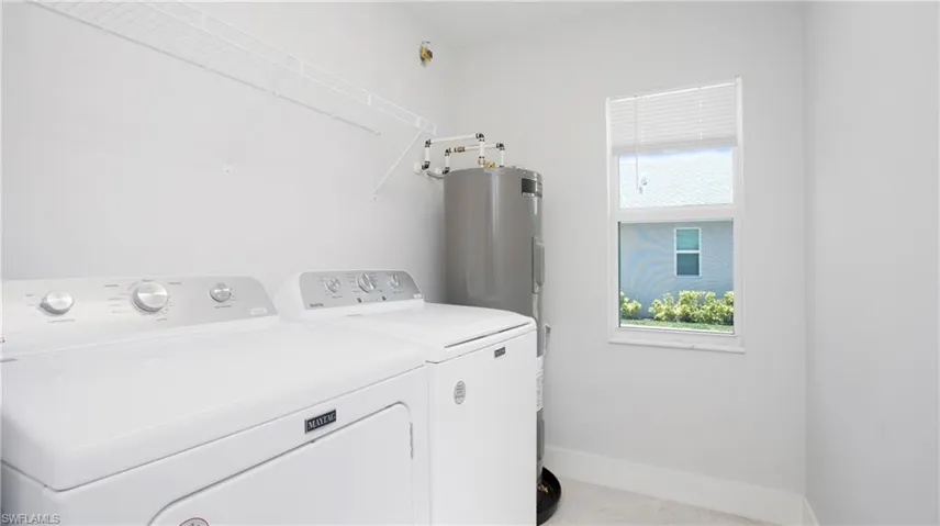 Laundry area with washing machine and dryer and baseboards