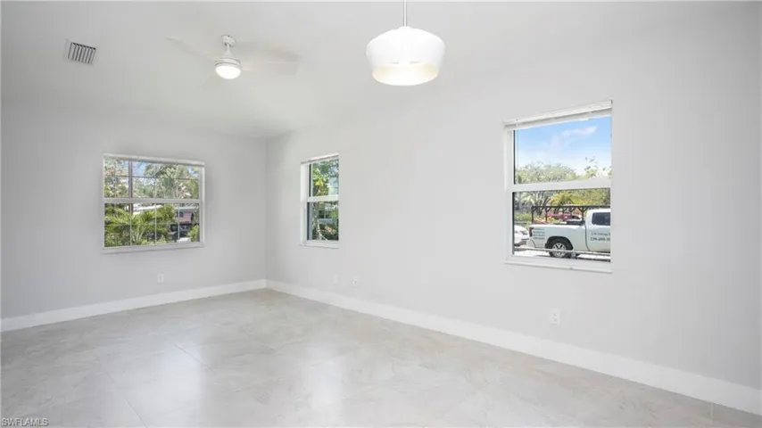 Empty room featuring plenty of natural light, baseboards, and ceiling fan