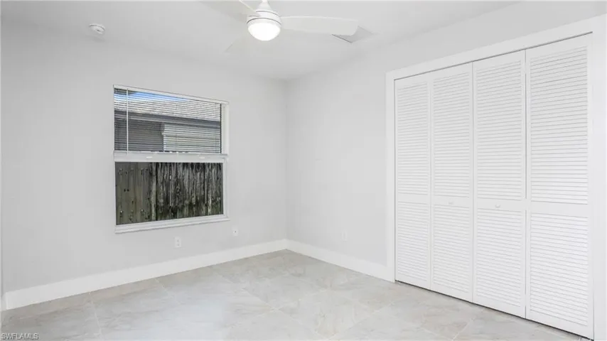 Unfurnished bedroom featuring a closet, baseboards, and a ceiling fan