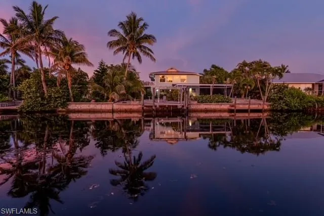 Twilight water view featuring boat lift and a boat dock