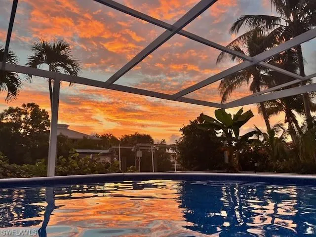 Pool at dusk featuring an outdoor pool and glass enclosure