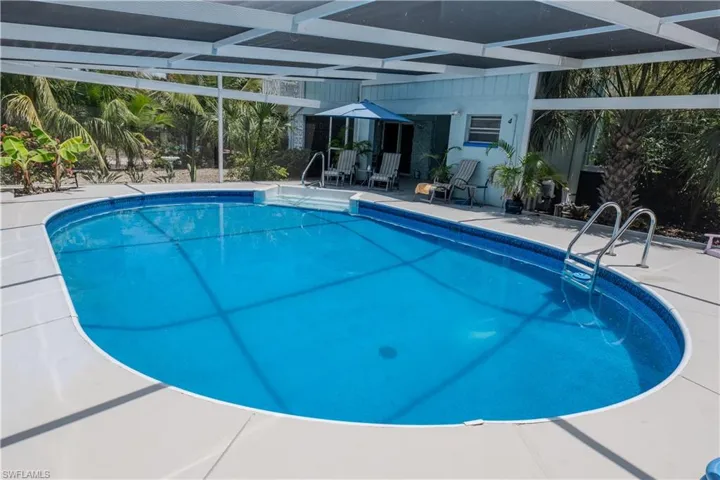 Swimming pool with a patio and glass enclosure