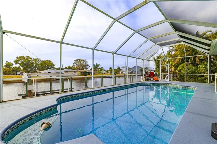 Outdoor pool with a sunroom, glass enclosure, a residential view, a dock, and a water view