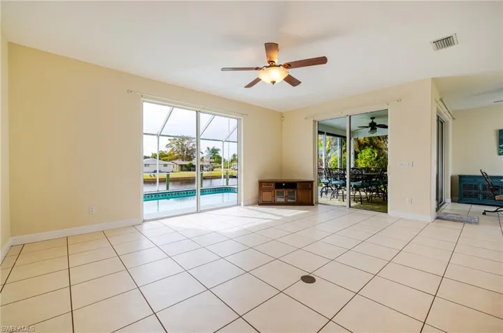 Unfurnished room with a sunroom, light tile patterned floors, and a ceiling fan