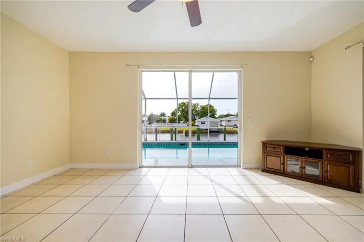 Unfurnished room featuring a ceiling fan, a sunroom, and light tile patterned flooring