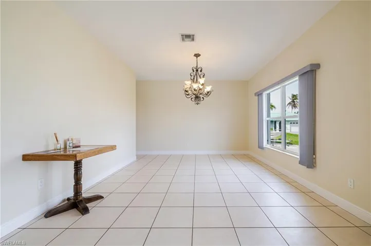 Unfurnished dining area with suspended lighting and light tile patterned floors