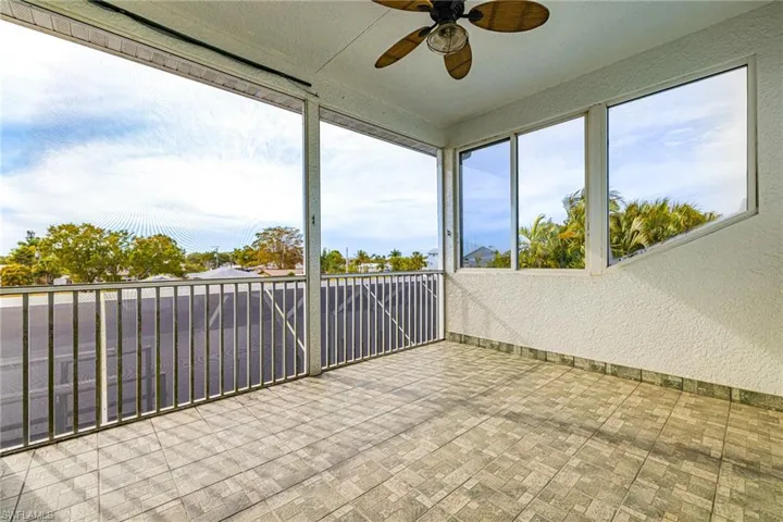 Unfurnished sunroom featuring ceiling fan