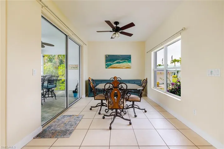 Dining space with ceiling fan and light tile patterned flooring
