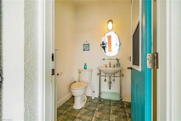 Half bathroom featuring toilet and baseboards