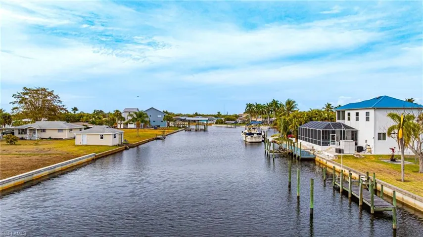 Dock area with a water view, a residential view, a yard, and boat lift