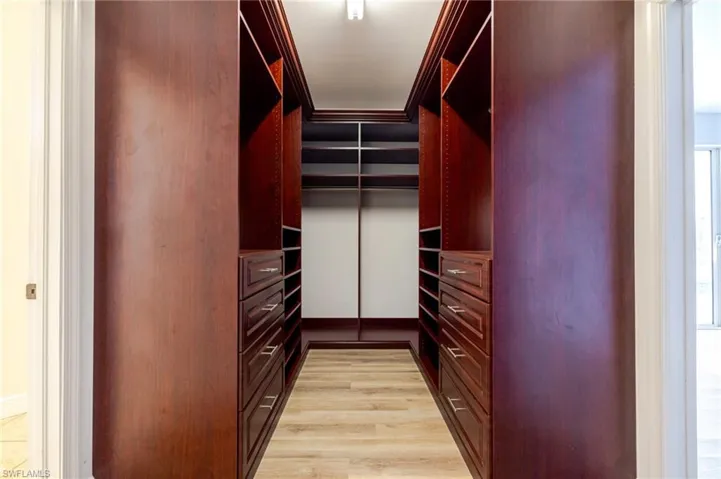 Walk in closet with light wood finished floors