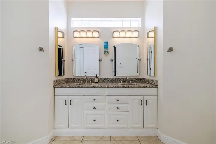 Bathroom featuring double vanity and light tile patterned flooring