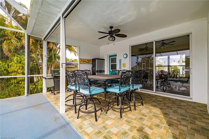Sunroom featuring outdoor dining space, a patio, and ceiling fan