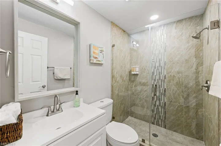 Bathroom featuring vanity, toilet, and a shower with shower door