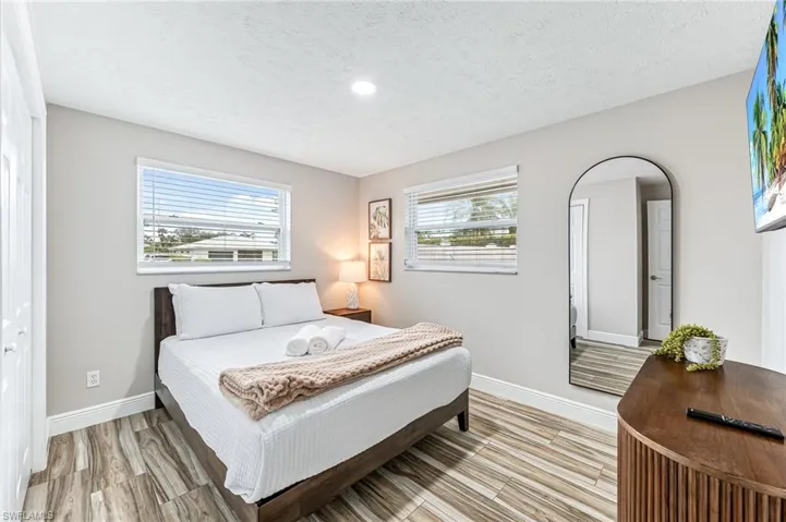 Bedroom featuring a closet, light hardwood / wood-style flooring, and a textured ceiling