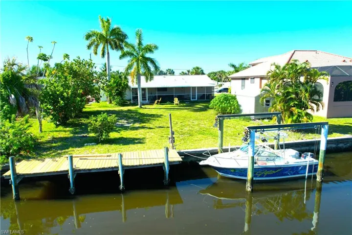 Dock area with a water view and a yard