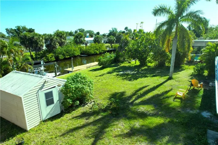 View of yard with a water view and a storage shed