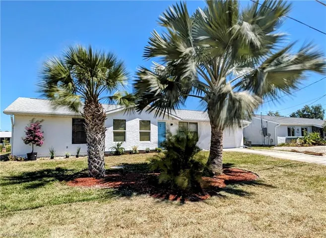 View of front facade featuring a front lawn and a garage
