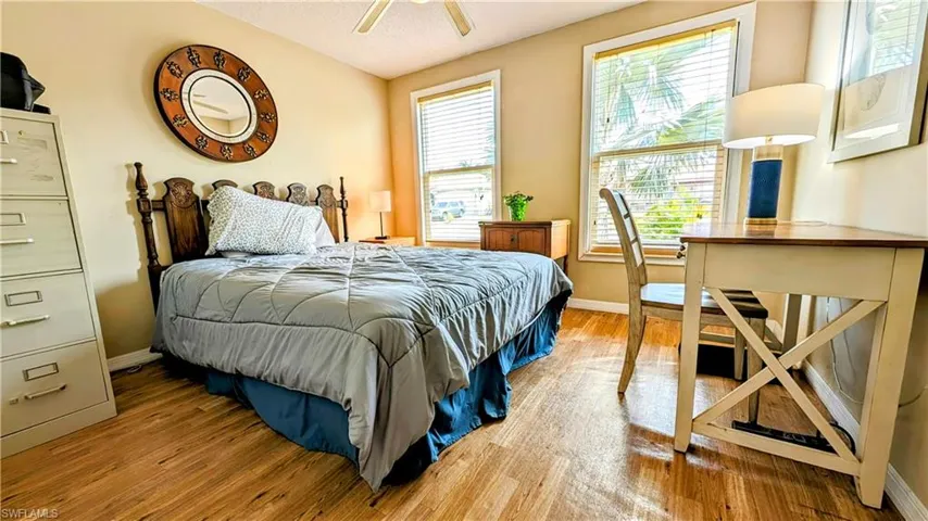 Bedroom with / wood-style flooring, multiple windows, and ceiling fan