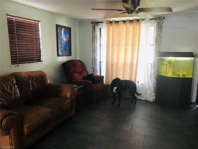 Living room with dark tile flooring and ceiling fan