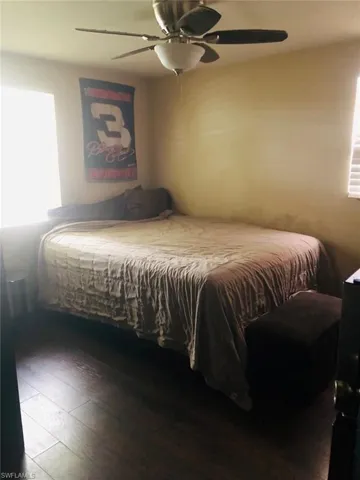Bedroom with hardwood / wood-style floors and ceiling fan