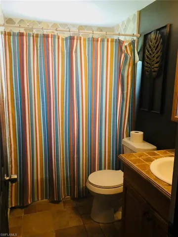 Bathroom featuring tile flooring, toilet, and vanity