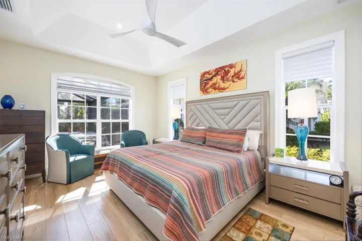 Bedroom featuring multiple windows, ceiling fan, and light wood-type flooring