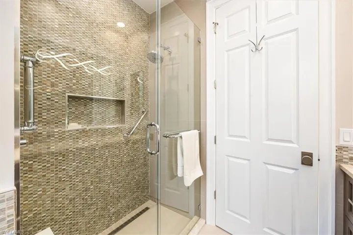 Bathroom with tile patterned floors, vanity, and an enclosed shower