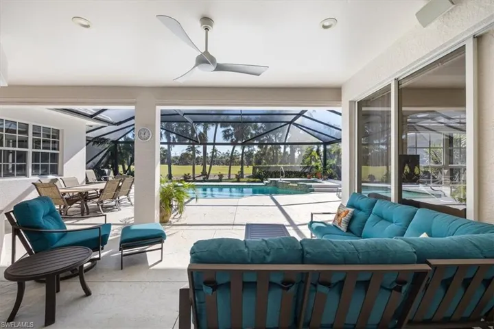View of patio / terrace featuring an outdoor living space, ceiling fan, a lanai, and a pool with hot tub