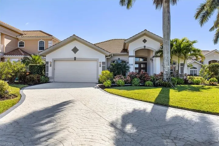 Mediterranean / spanish home with a garage and a front lawn