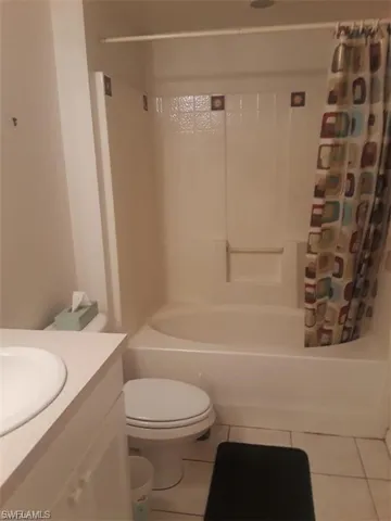 Full bathroom featuring vanity, toilet, tile patterned floors, and shower / bath combo