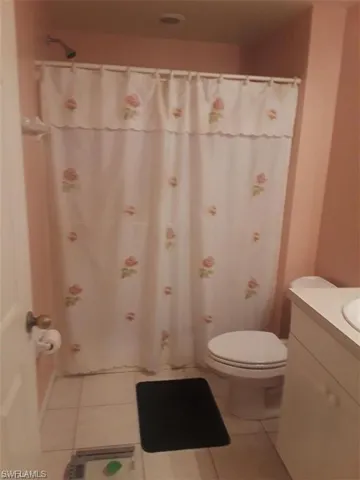 Bathroom with vanity, toilet, and tile patterned flooring
