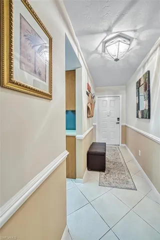 Hallway featuring light tile patterned floors and baseboards
