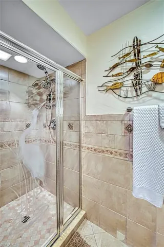 Full bath with a shower stall and tile patterned floors
