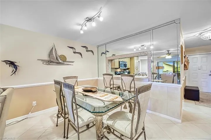Dining space with a ceiling fan, light tile patterned flooring, and rail lighting