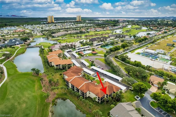 Aerial perspective of suburban area with a nearby body of water and a golf course