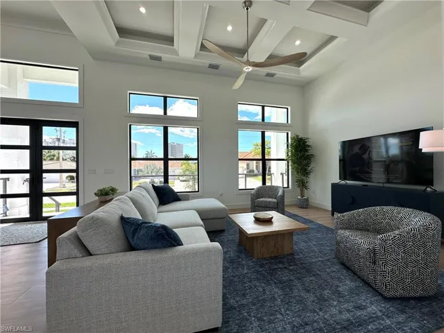 Living room with a ceiling fan, coffered ceiling, dark wood finished floors, and recessed lighting