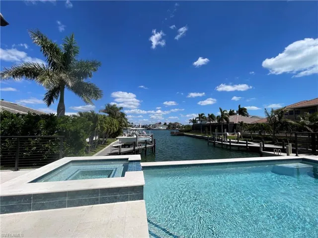 Relaxing pool / spa featuring a water view, a dock, and boat lift