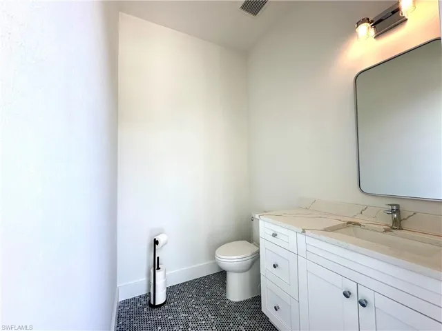 Bathroom featuring vanity and dark tile patterned floors