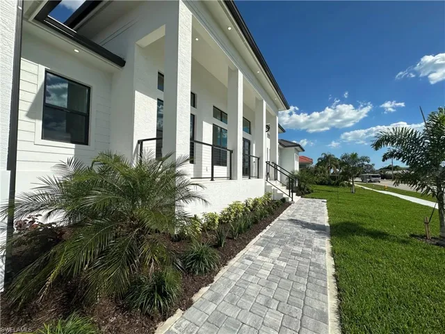 View of side of home featuring a yard, stucco siding, and covered porch