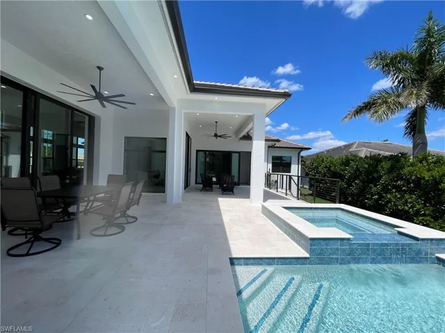 Integrated pool / hot tub with outdoor dining space and a patio