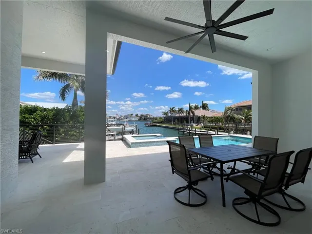 View of patio featuring outdoor dining area, a ceiling fan, and a pool with connected hot tub
