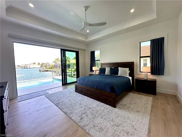 Bedroom with access to outside, ceiling fan, light wood-type flooring, recessed lighting, and a water view